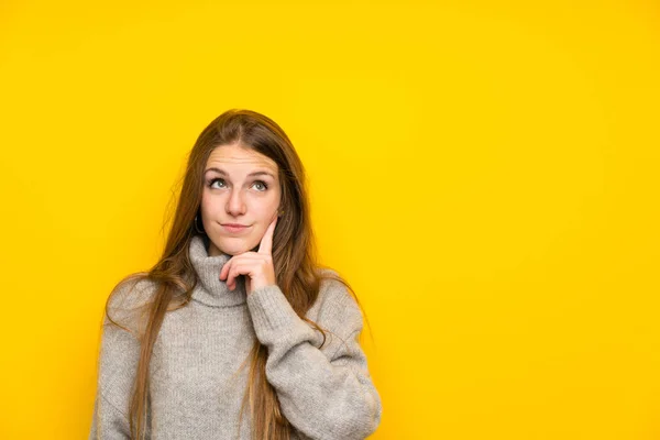 Jonge Vrouw Met Lang Haar Gele Achtergrond Denken Een Idee — Stockfoto