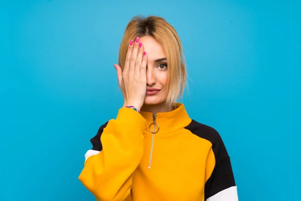 Jovem Loira Sobre Isolado Fundo Azul Cobrindo Olho Mão — Fotografia de Stock