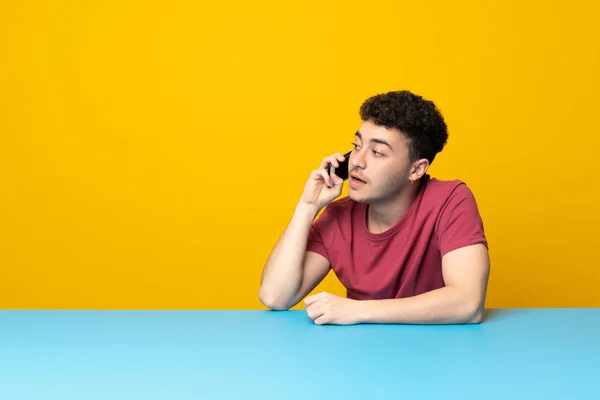 Young Man Colorful Wall Table Keeping Conversation Mobile Phone — 스톡 사진