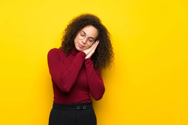 Dominican woman with turtleneck sweater making sleep gesture in dorable expression