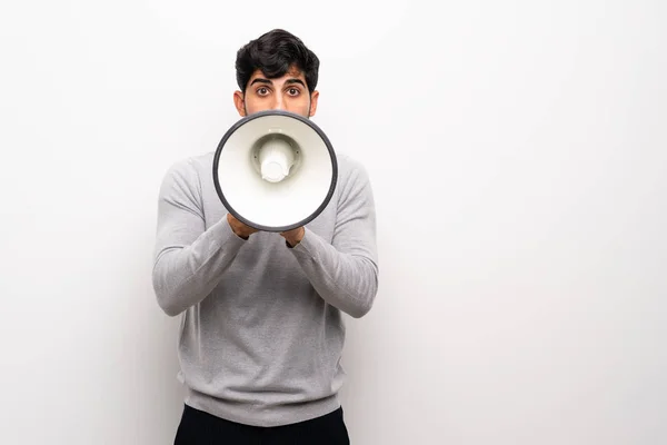 Joven Sobre Una Pared Blanca Aislada Gritando Través Megáfono — Foto de Stock