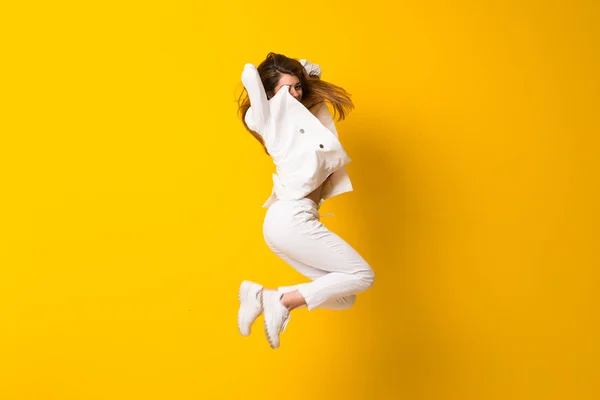 Mujer Joven Saltando Sobre Pared Amarilla Aislada —  Fotos de Stock