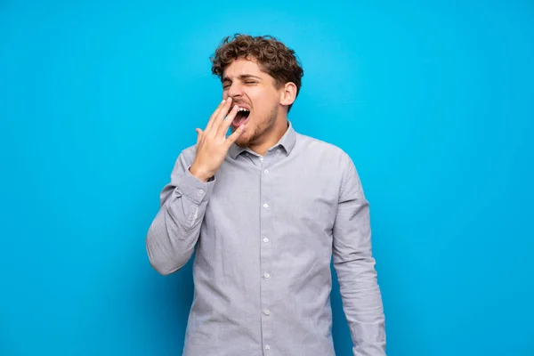 Blonde Man Blauwe Muur Geeuwen Bedekt Brede Open Mond Met — Stockfoto