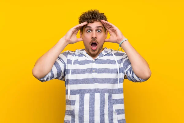 Homem Loiro Sobre Parede Amarela Com Surpresa Expressão Facial Chocada — Fotografia de Stock