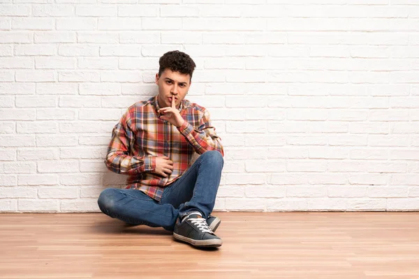 Νέος Άνθρωπος Κάθεται Στο Πάτωμα Δείχνοντας Ένα Σημάδι Της Σιωπής — Φωτογραφία Αρχείου