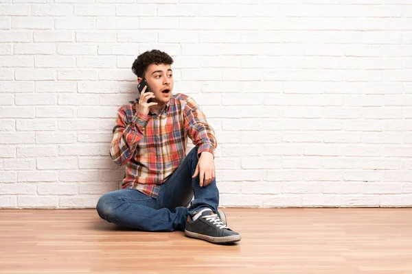 Mladý Muž Sedí Podlaze Vede Rozhovor Mobilním Telefonem — Stock fotografie