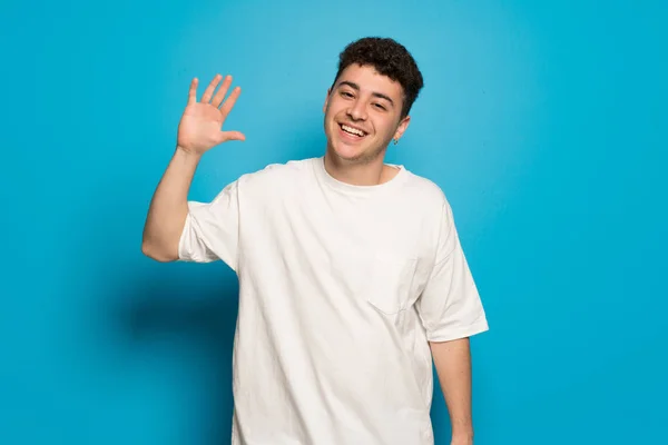 Young Man Blue Background Saluting Hand Happy Expression — 스톡 사진