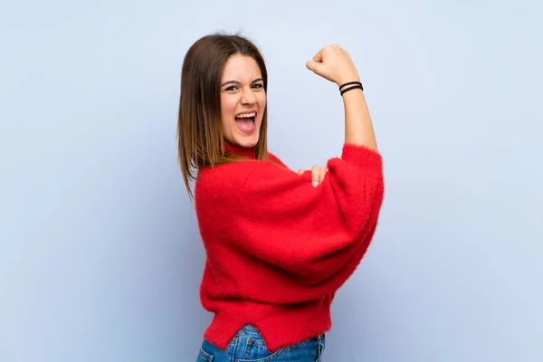 Mujer Joven Sobre Aislada Pared Azul Haciendo Gesto Fuerte —  Fotos de Stock