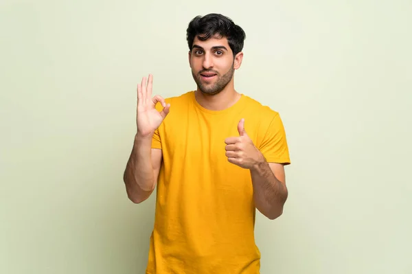 Молодий Чоловік Над Рожевою Стіною Показуючи Знак Даючи Великий Палець — стокове фото
