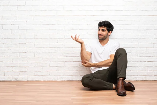 Young Man Sitting Floor Extending Hands Side Inviting Come — Stock Photo, Image