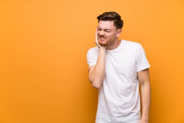 Diş ağrısı ile kahverengi duvar üzerinde Redhead adam