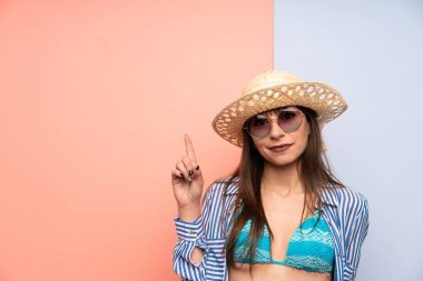 Bikinili genç bir kadın işaret parmağıyla işaret ediyor. Harika bir fikir.