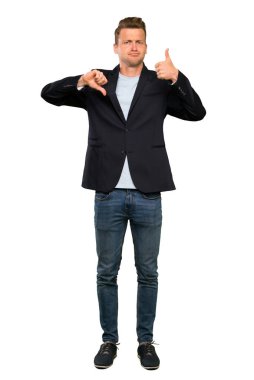 Sarışın yakışıklı adam iyi-kötü işareti yapıyor. Evet ya da değil arasında kararsız