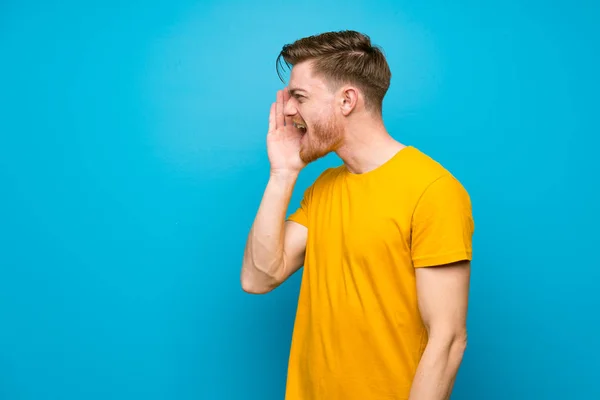 Redhead Man Blue Wall Shouting Mouth Wide Open Lateral — Stock Photo, Image