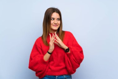 Genç bir kadın, izole edilmiş mavi duvar entrikaları çeviriyor.