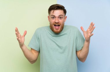 Sürpriz yüz ifadesi ile renkli arka plan üzerinde Redhead adam