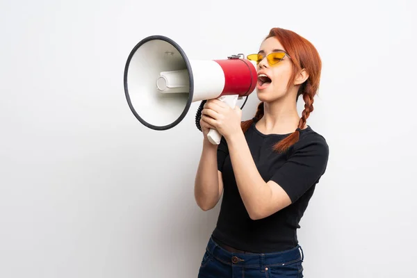 Giovane Rossa Donna Oltre Muro Bianco Gridando Attraverso Megafono — Foto Stock