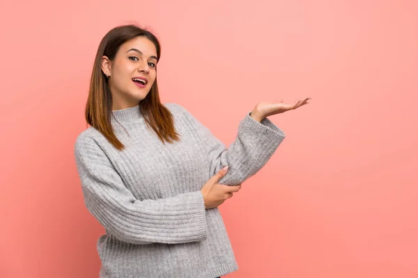 Jovem Mulher Sobre Parede Rosa Estendendo Mãos Para Lado Para — Fotografia de Stock