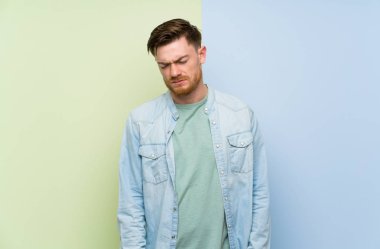 Üzgün ve depresif ifade ile renkli arka plan üzerinde Redhead adam
