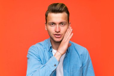 İzole duvar üzerinde sarışın yakışıklı adam bir şey fısıldayan