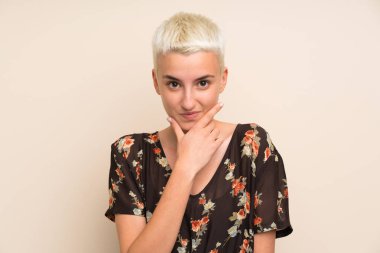 İzole edilmiş duvarın üzerinde duran ve bir fikir düşünen genç bir kadın.