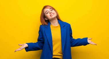 Trençkotlu genç kızıl saçlı kadın gülümsüyor.