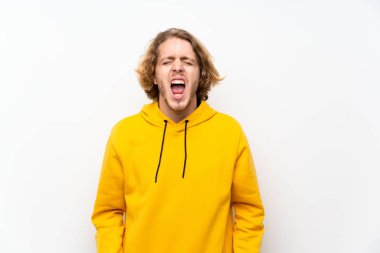 Beyaz duvar üzerinde sweatshirt ile Sarışın adam ağzı geniş açık ön bağırarak