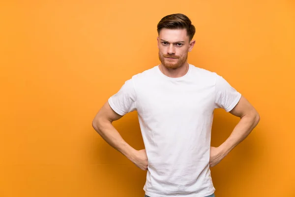 Redhead man over brown wall angry