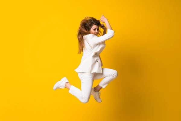 Mujer Joven Saltando Sobre Pared Amarilla Aislada —  Fotos de Stock