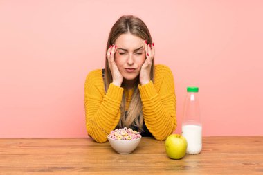 Bir kase mısır gevreğiyle mutsuz ve hayal kırıklığına uğramış genç bir kadın. Olumsuz yüz ifadesi