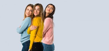 renkli arka planda bir gülümseme ile omuz üzerinden bakan renkli giysiler ile insanların grup