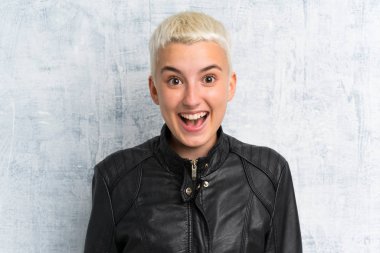 Sürpriz yüz ifadesi ile grunge duvar üzerinde genç kadın