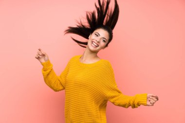 Genç kız pembe duvar üzerinde dans