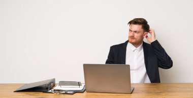 Kafa nı kaşırken şüpheleri olan bir ofisteki işadamı