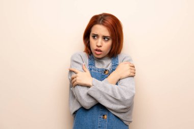 Genç kızıl saçlı kadın izole edilmiş arka planda donuyor.