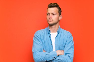 İzole duvar ayakta ve görünümlü yan üzerinde sarışın yakışıklı adam