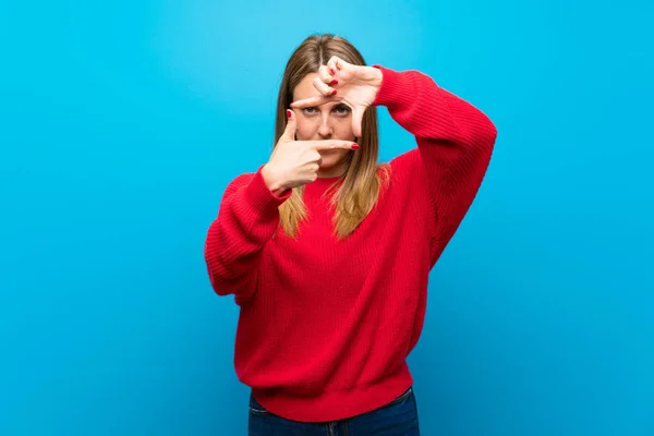 Mujer Con Suéter Rojo Sobre Pared Azul Enfocando Cara Símbolo —  Fotos de Stock