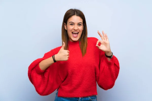 Jonge Vrouw Geïsoleerde Blauwe Muur Toont Teken Duim Omhoog Gebaar — Stockfoto