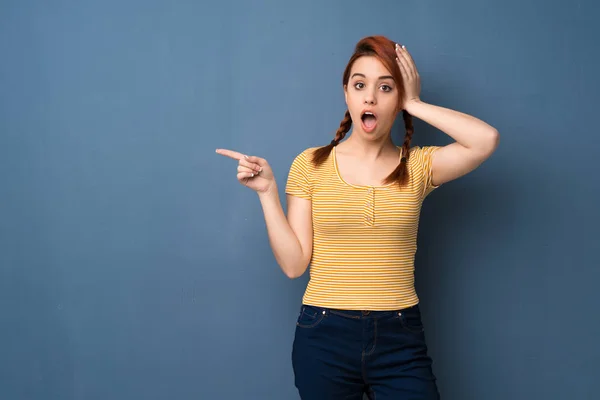 Young Redhead Woman Blue Background Pointing Finger Side Presenting Product — 스톡 사진