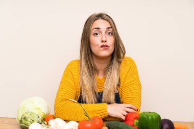 Bir sürü sebzesi olan, kuşkulu ve kafası karışık bir kadın.