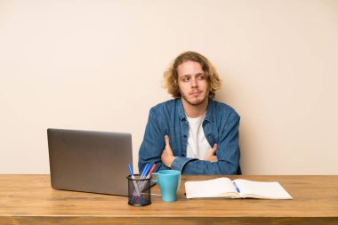 Bir dizüstü bilgisayar ayakta ve yan bakıyor sarışın adam