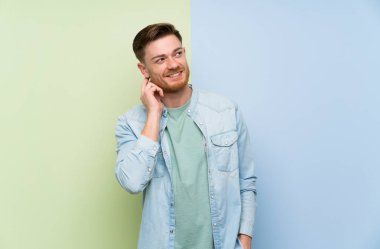 Renkli arka plan üzerinde Redhead adam bir fikir düşünme