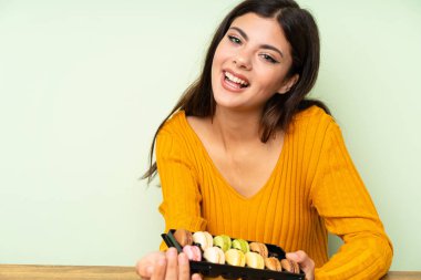 Yeşil duvar üzerinde macaroons ile Happy Genç kız