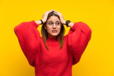 Sürpriz yüz ifadesi ile izole sarı duvar üzerinde genç kadın