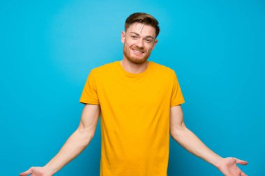 Mavi duvar üzerinde Redhead adam gülümseyerek
