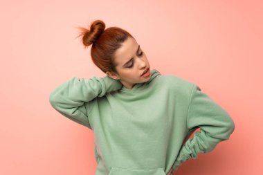 Boynunda kazak olan genç, kızıl saçlı bir kadın.