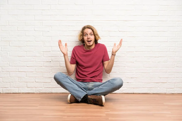 Ξανθός Άνθρωπος Κάθεται Στο Πάτωμα Σοκαρισμένος Έκφραση Του Προσώπου — Φωτογραφία Αρχείου