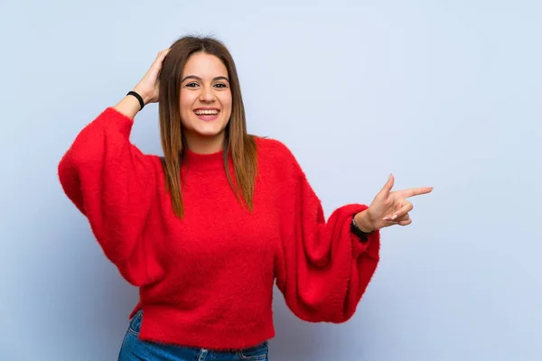 Junge Frau Über Isolierte Blaue Wand Überrascht Und Zeigt Mit — Stockfoto