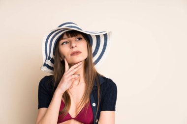 Bikini giyen kadın, arka planda bir fikir düşünüyor.