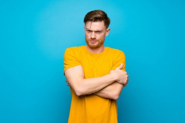 Mavi duvar üzerinde Redhead adam üzgün hissediyorum